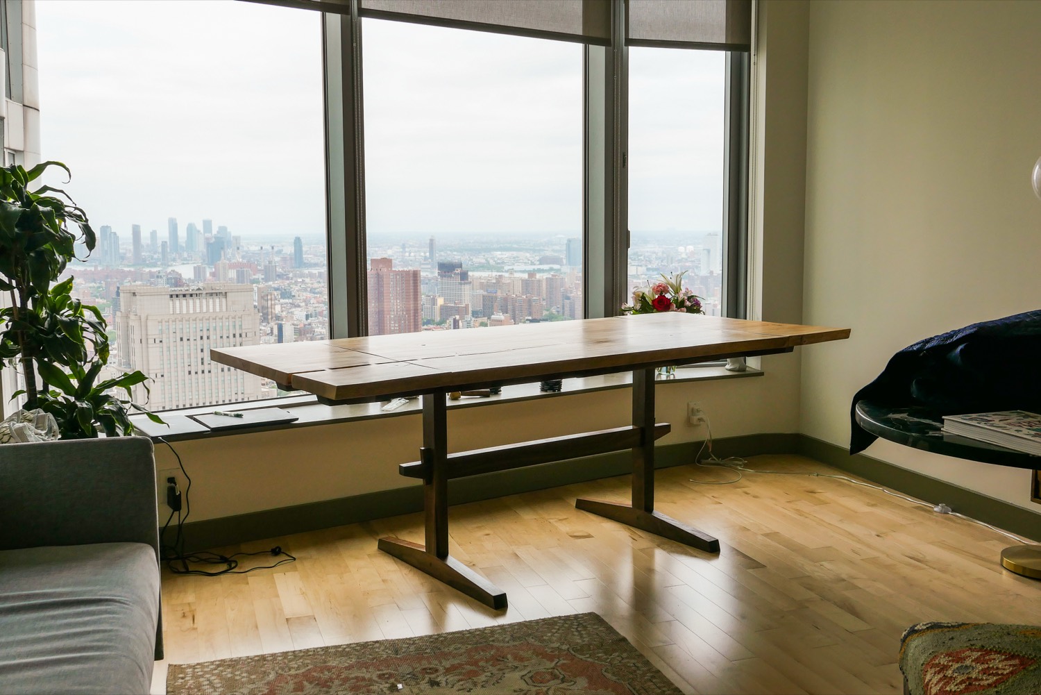 Trestle dining table in front of a city window