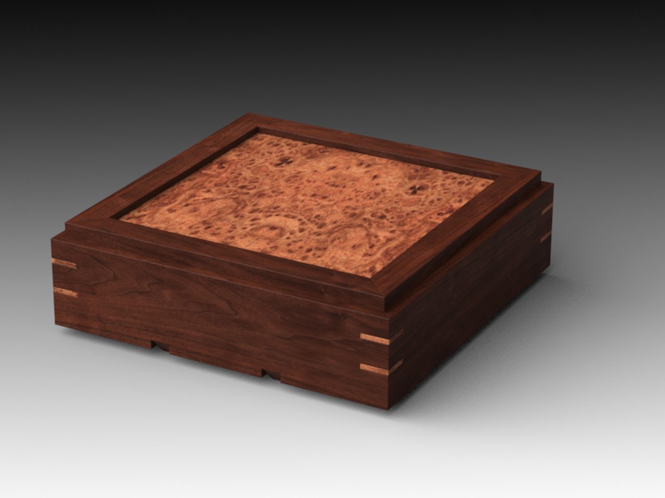 A walnut keepsake box with a framed burl-panel lid and pale contrasting splines at the corners